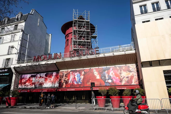Štirinajst mesecev po tem, ko se je vetrnica mlina ponoči zrušila, so najbolj znano arhitekturno značilnost Moulin Rougea v celoti obnovili. FOTO: Bertrand Guay/AFP