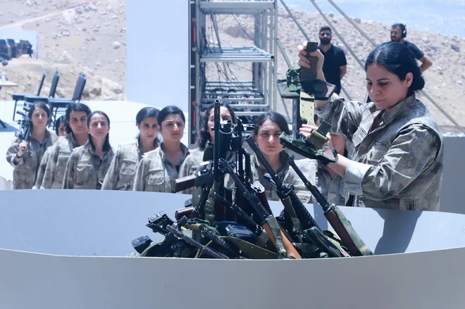 Trideset pripadnikov PKK, po 15 žensk in moških, je v petek v bližini Sulejmanije v iraškem Kurdistanu simbolno odložilo in zažgalo svoje orožje. FOTO: Shwan Mohammed/AFP