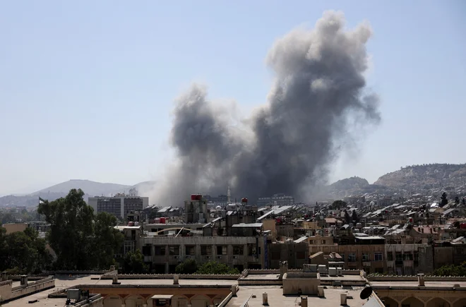 Dim nad napadenim obrambnim ministrstvom v Damasku. FOTO: Khalil Ashawi/Reuters