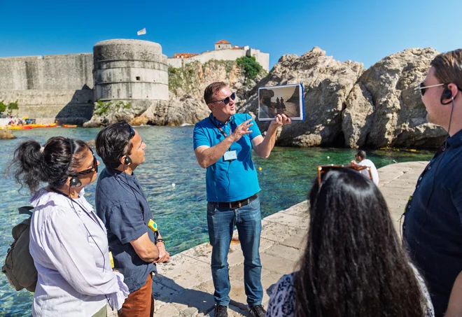 Turistični vodič v Dubrovniku turistom pripoveduje, kjer so snemali Igro prestolov. FOTO: Antonio Bronic/Reuters