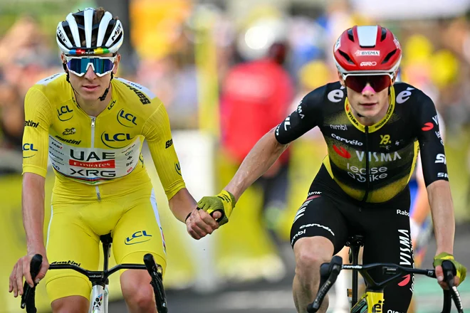 Tadej Pogačar in Jonas Vingegaard sta z roko v roki prečkala ciljno črto enajste etape. FOTO: Loic Venance/AFP
