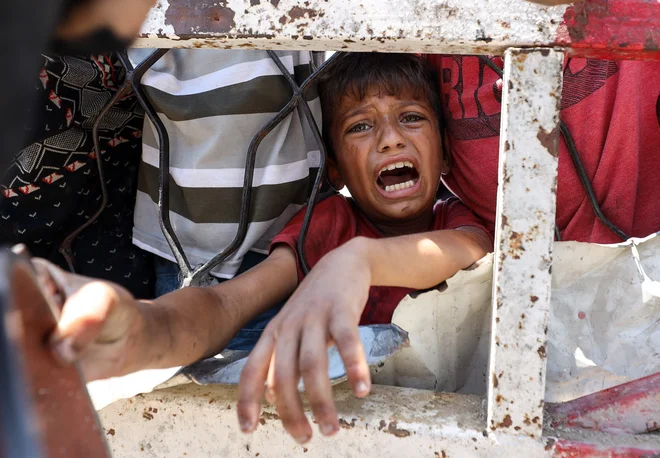 Sestradani Palestinci čakajo na hrano. FOTO: Khamis Al-rifi/Reuters