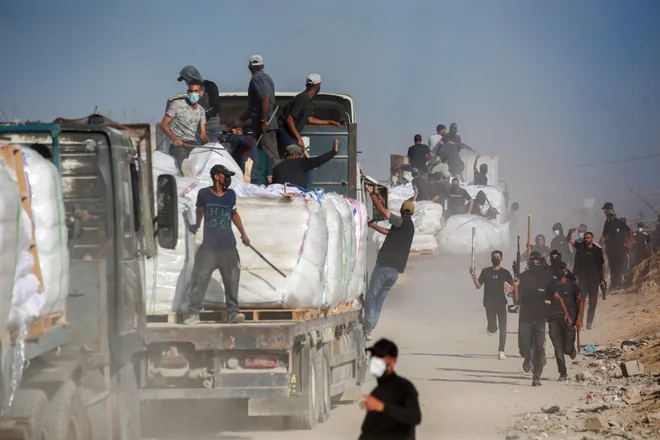 Samoorganizirani palestinski prostovoljci varujejo konvoje s hrano, da bi preprečili plenjenje. FOTO: Bashar Taleb/AFP