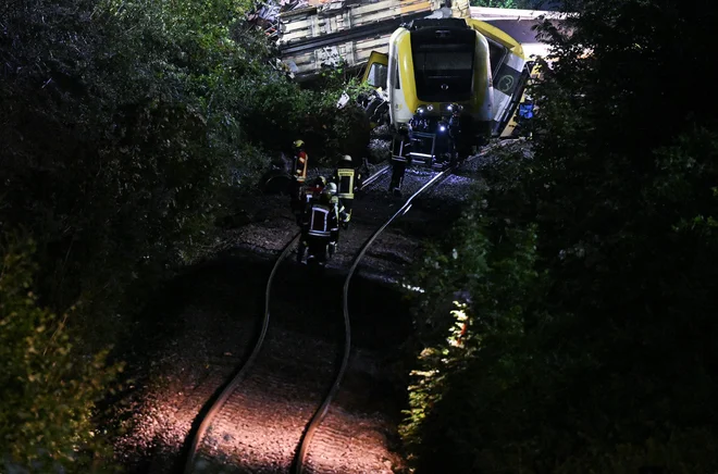 Reševalci pregledujejo kraj iztirjenja lokalnega vlaka v Riedlingenu blizu Biberacha, pri čemer je umrlo več potnikov. FOTO: Markus Ulmer/Reuters