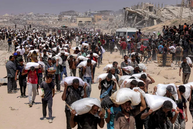 Izrael je začel izvajati taktične humanitarne premore, ki naj bi omogočili dobavo pomoči po t. i. humanitarnih koridorjih. V Gazo je iz Egipta prišlo okoli 100 tovornjakov z nujno potrebno humanitarno pomočjo za stradajoče prebivalce Gaze. Foto: Bashar Taleb/Afp