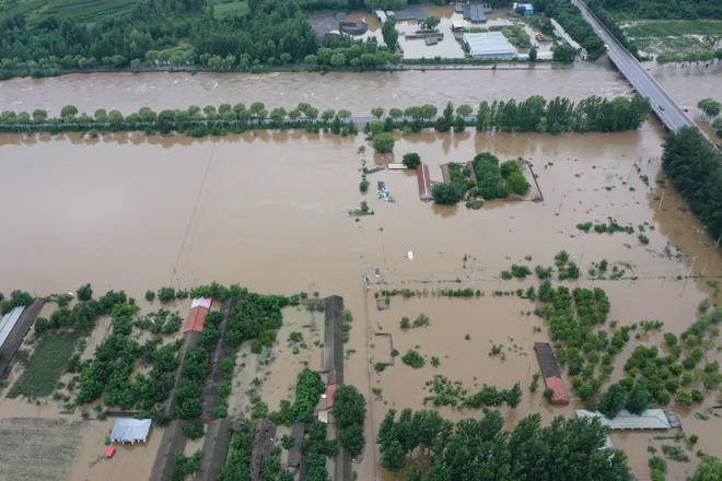 Peking je v ponedeljek izdal najvišje opozorilo pred dežjem in poplavami ter prebivalcem svetoval, naj ne zapuščajo svojih domov. FOTO: Adek Berry/AFP