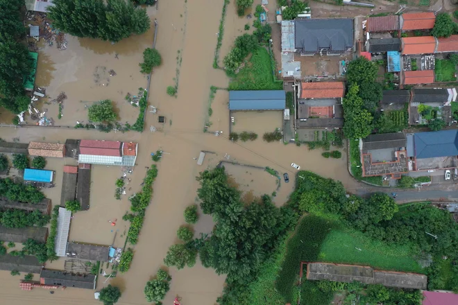 Močan dež je začel padati ta konec tedna in se v ponedeljek še okrepil v Pekingu in okoliških provincah. Po poročanju agencije Xinhua je v severnih delih prestolnice padlo do 543,4 milimetra dežja. FOTO: Adek Berry/AFP