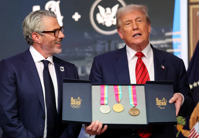 Ameriški predsednik Donald Trump je od organizatorjev prejel simbolični komplet medalj z iger v Los Angelesu leta 1984. FOTO: Jonathan Ernst/Reuters