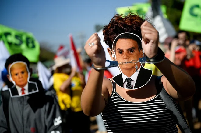 Protestniki so se pred dnevi zbrali tudi pred veleposlaništvom ZDA v brazilskem glavnem mestu, opremljeni z maskami nekdanjega predsednika Bolsonara in njegovega ameriškega zaveznika Trumpa. FOTO: Mateus Bonomi/Reuters