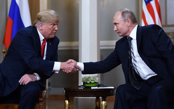 Ameriški predsednik Donald Trump in ruski voditelj Vladimir Putin med stiskom rok na njunem srečanju v Helsinkih julija 2018.

FOTO: Brendan Smialowski/AFP
