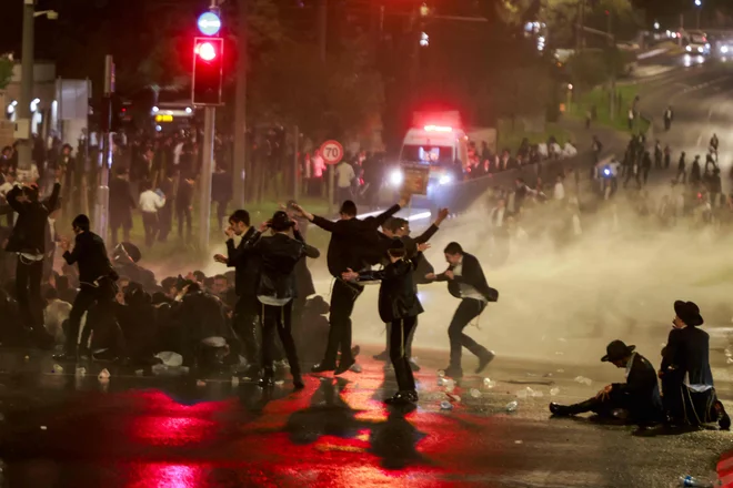 Izraelska policija je v Jeruzalemu z vodnim topom razgnala ultraortodoksne judovske demonstrante, ki so protestirali proti vojaški obveznosti v izraelski vojski in aretaciji študentov verskih šol, ki so se izognili vojaški obveznosti. Vojaška obveznost ultraortodoksnih Judov je za izraelsko družbo, katere večji del mora služiti v vojski, zelo sporna tema. V skladu z dogovorom, ki velja od ustanovitve Izraela leta 1948, so ultraortodoksni Judje oproščeni vojaške službe, če se posvečajo verskim študijem. Toda javna podpora za oprostitve je upadla, zlasti ker vojska po več kot 21 mesecih vojne v Gazi sooča s pomanjkanjem kadrov. Foto: Menahem Kahana/Afp