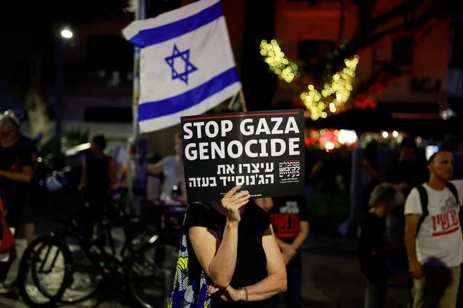 Med protestom v podporo talcem, ki jih je Hamas zajel 7. oktobra 2023, je izraelska protestnica nosila napis: »Ustavite genocid v Gazi.« FOTO: Ammar Awad/Reuters