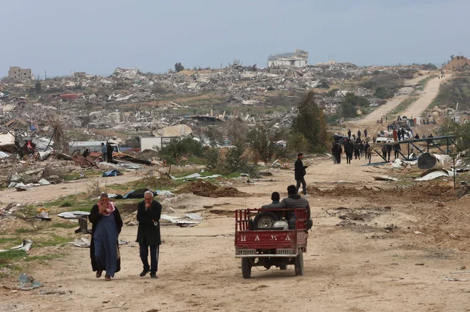 Razseljeni Palestinci prečkajo t. i. koridor Netzarim, obomočje, ki ga je izraleska vojska uničila in iz njega izgnala številne prebivalce. FOTO: Omar Al-qattaa/AFP