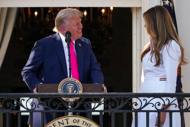 Zakonca Trump na balkonu Bele hiše na dan, ko naj bi podpisal »veliki čudoviti zakon«. FOTO: Ken Cedeno/Reuters