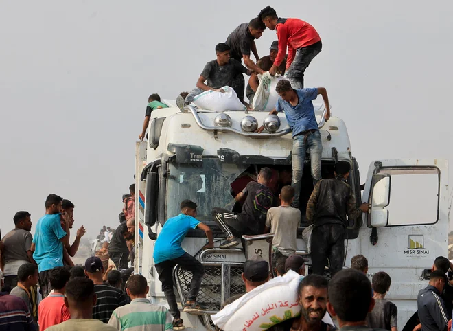 Palestinci skušajo priti do hrane, ki je prišla skozi Izrael. FOTO: Hatem Khaled/Reuters